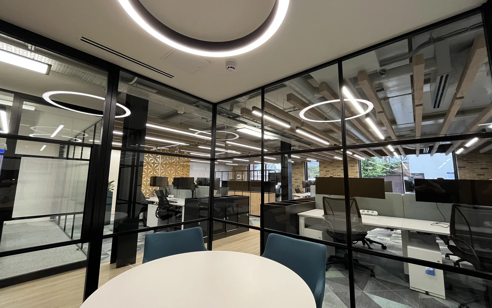 circular lighting an office with a table and two chairs.