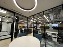 circular lighting an office with a table and two chairs.