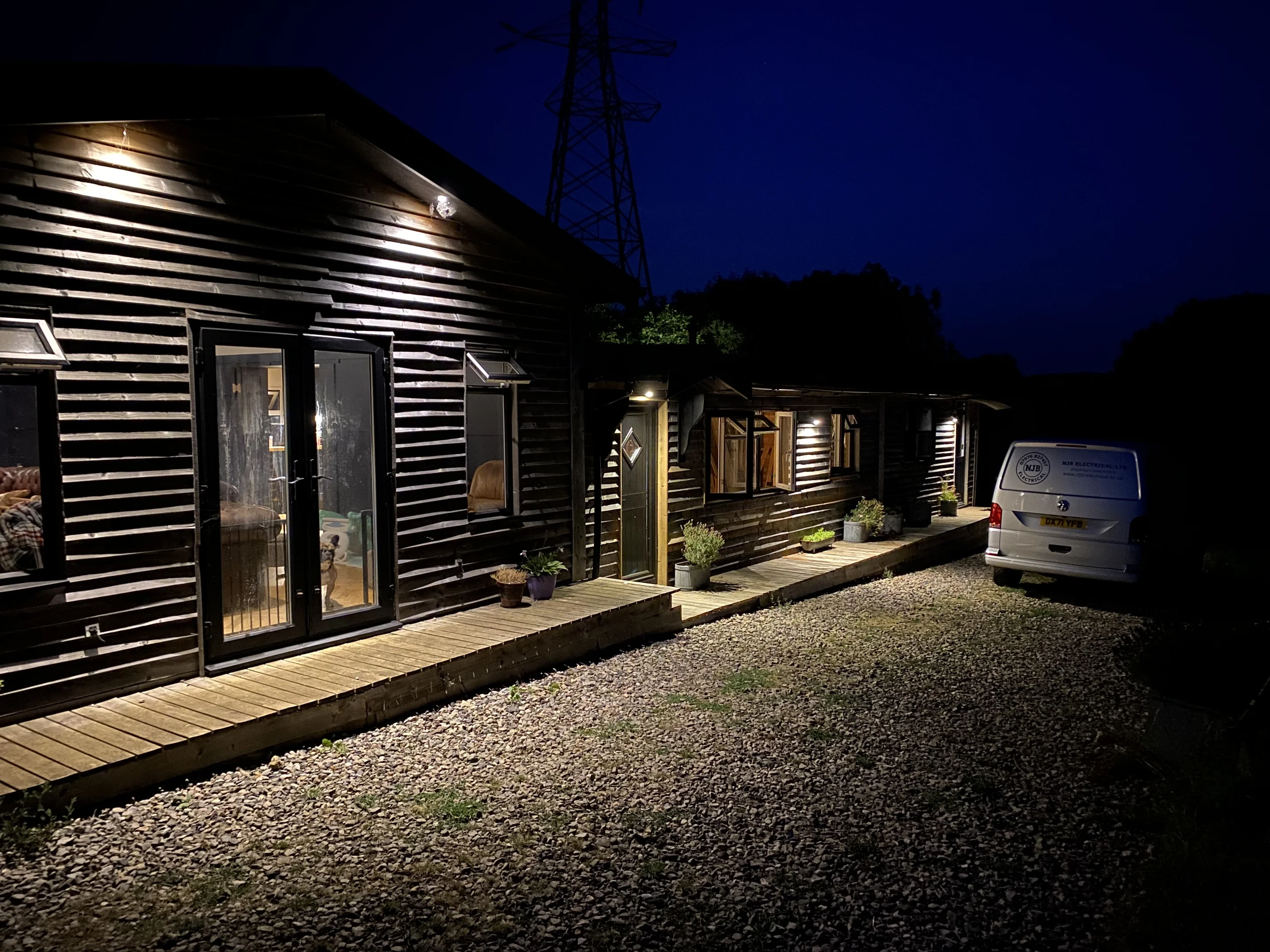 house with dark lighting and van at the end of the drive